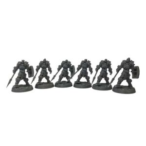 A front-view photograph of six unpainted grey resin skeleton heavy infantry miniatures against a white background. The bulky skeletal figures are heavily armored in thick plates with fur trim, each holding a long spear and carrying a rectangular shield. They are posed in combat stances on circular, cobblestone-textured bases.